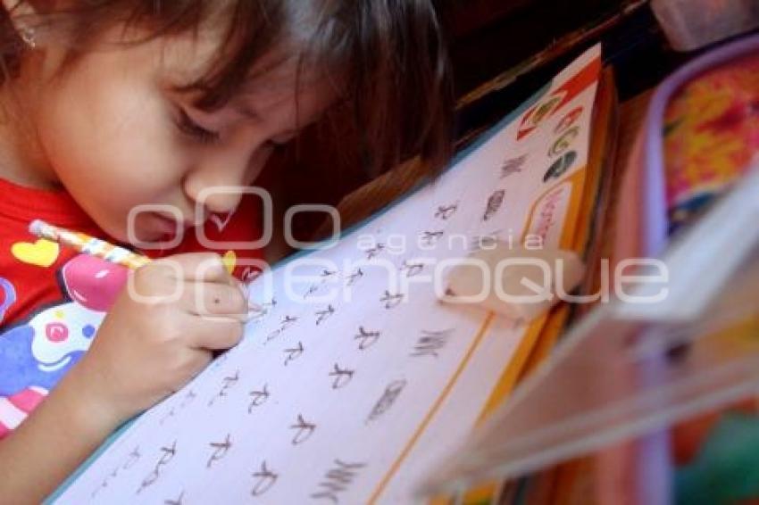 NIÑA APRENDE A ESCRIBIR