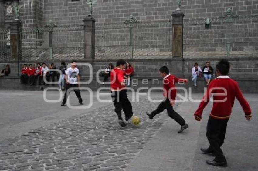 ESTUDIANTES JUEGAN FUTBOL A UN COSTADO DE CATEDRAL