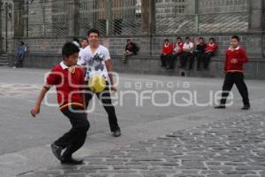 ESTUDIANTES JUEGAN FUTBOL A UN COSTADO DE CATEDRAL