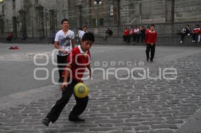 ESTUDIANTES JUEGAN FUTBOL A UN COSTADO DE CATEDRAL