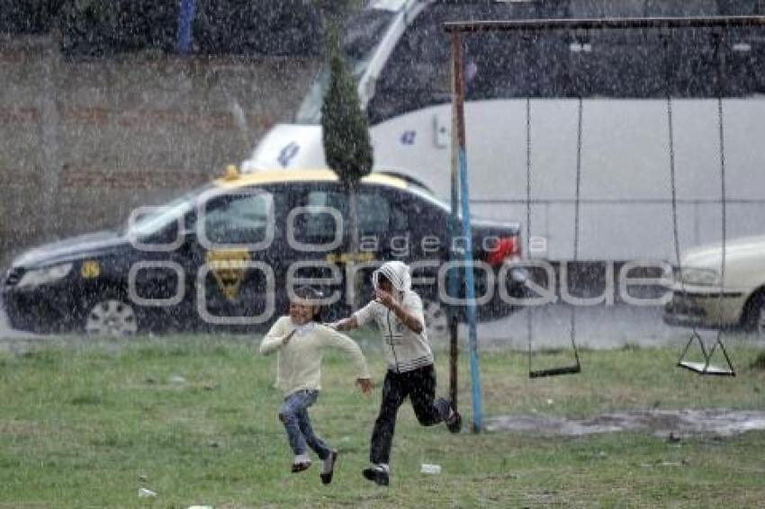 NIÑAS JUEGAN BAJO LA LLUVIA