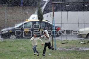 NIÑAS JUEGAN BAJO LA LLUVIA