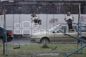 NIÑAS JUEGAN BAJO LA LLUVIA