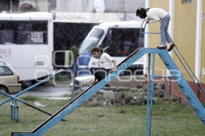 NIÑAS JUEGAN BAJO LA LLUVIA